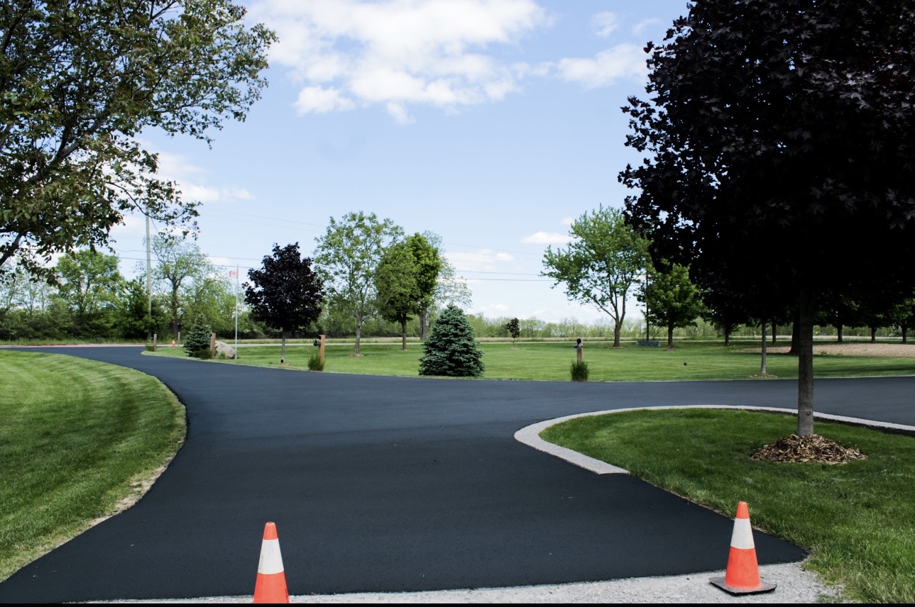 Freshly sealed curved asphalt driveway